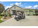 Charming home featuring a well-manicured lawn, two car garage, and golf cart parked in the driveway at 946 Isle Of Palms Path, The Villages, FL 32162