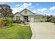 Beautiful single-story home with lush green lawn, neatly trimmed bushes, and a clean, inviting driveway at 946 Isle Of Palms Path, The Villages, FL 32162