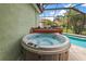Inviting backyard hot tub for relaxation and entertainment with screened-in pool and outdoor area at 946 Isle Of Palms Path, The Villages, FL 32162