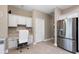 Bright kitchen with a desk area, white cabinets, stainless steel refrigerator, and tile flooring at 946 Isle Of Palms Path, The Villages, FL 32162
