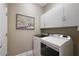 Bright laundry room with front loading washer and dryer and white cabinets at 946 Isle Of Palms Path, The Villages, FL 32162