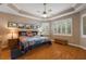 Serene bedroom with tray ceiling, hardwood floors, shuttered windows and a queen-size bed at 946 Isle Of Palms Path, The Villages, FL 32162