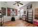 Bedroom with laminate wood flooring, ceiling fan, and displays showcasing racing memorabilia and sports at 10240 Kabana Blvd, Clermont, FL 34711