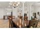 Elegant dining room with a large chandelier, dark wood table, and view into living spaces at 10240 Kabana Blvd, Clermont, FL 34711
