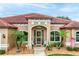 Close-up of a beautiful entryway showcasing arched windows, decorative plants, and seating at 10240 Kabana Blvd, Clermont, FL 34711