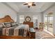 Spacious main bedroom featuring a tray ceiling, ceiling fan, wood floors, and an en suite bathroom at 10240 Kabana Blvd, Clermont, FL 34711