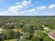 Expansive aerial view of the wooded area surrounding the home featuring a lake with a dock at 10303 Se Sunset Harbor Rd, Summerfield, FL 34491