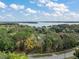 Panoramic aerial view of the property nestled among lush trees and overlooking a serene lake at 10303 Se Sunset Harbor Rd, Summerfield, FL 34491
