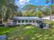 A tranquil view of the well-kept lawn, the inviting covered patio, and the calming backyard at 10303 Se Sunset Harbor Rd, Summerfield, FL 34491