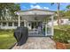 Outdoor living space with grill, ceiling fan and view of the yard and features patio furniture with blue cushions at 10303 Se Sunset Harbor Rd, Summerfield, FL 34491