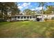 The property boasts a well-maintained lawn, and covered patio area with a outdoor furniture at 10303 Se Sunset Harbor Rd, Summerfield, FL 34491