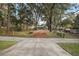 Property view of a long driveway leading to a single story home, nestled among trees in a serene setting at 10303 Se Sunset Harbor Rd, Summerfield, FL 34491