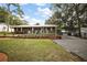 Charming brick home with manicured lawn, a front patio, metal carport, and inviting curb appeal at 10303 Se Sunset Harbor Rd, Summerfield, FL 34491