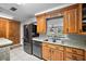 Efficient kitchen with wooden cabinets, stainless steel appliances, and natural light from the window at 10303 Se Sunset Harbor Rd, Summerfield, FL 34491