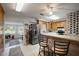 Open kitchen with stainless steel appliances, tile floors, and breakfast bar with seating at 10303 Se Sunset Harbor Rd, Summerfield, FL 34491