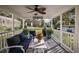 Covered patio with seating, ceiling fan, and view of the landscaped backyard at 10303 Se Sunset Harbor Rd, Summerfield, FL 34491