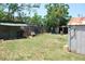 Spacious backyard featuring sheds and functional outdoor sink, perfect for projects at 1095 Golden Isle Dr, Mount Dora, FL 32757