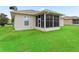 Well-manicured lawn and screened in porch in this property's backyard offers relaxation and outdoor living at 11019 Se 170Th Lane Rd, Summerfield, FL 34491
