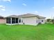 Manicured lawn in backyard leads to the back door and screened in porch at 11019 Se 170Th Lane Rd, Summerfield, FL 34491