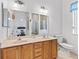 Well-lit bathroom has double sinks, wood cabinets, a tile floor, and a shower in a bright, spacious area at 11019 Se 170Th Lane Rd, Summerfield, FL 34491