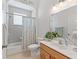 Bathroom featuring vanity with marble countertop, neutral tile backsplash, and shower-tub combo with floral curtain at 11019 Se 170Th Lane Rd, Summerfield, FL 34491
