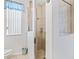 Bathroom featuring tiled floors, a glass-enclosed shower, and a window with white blinds for natural light at 11019 Se 170Th Lane Rd, Summerfield, FL 34491