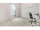 Bright bedroom with carpeted floors, a large window, and a desk, ideal for a home office setup at 11019 Se 170Th Lane Rd, Summerfield, FL 34491