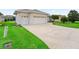 A long driveway leads to a spacious three-car garage, surrounded by lush green lawns at 11019 Se 170Th Lane Rd, Summerfield, FL 34491