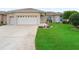 A well manicured lawn and three-car garage provide great curb appeal to this house at 11019 Se 170Th Lane Rd, Summerfield, FL 34491