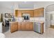 The functional kitchen features wood cabinets, a stainless steel dishwasher, and a pass-through to the dining area at 11019 Se 170Th Lane Rd, Summerfield, FL 34491