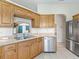 Functional kitchen area with ample wood cabinets, stainless steel appliances, and an archway to adjacent spaces at 11019 Se 170Th Lane Rd, Summerfield, FL 34491