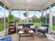 Bright sunroom with large windows, comfortable seating, plants, and a view of the beautiful backyard at 11019 Se 170Th Lane Rd, Summerfield, FL 34491