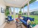 Inviting sunroom featuring ample natural light, comfortable seating, and a view of the landscaped backyard at 11019 Se 170Th Lane Rd, Summerfield, FL 34491