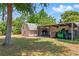 Backyard featuring storage sheds, lawn equipment, and some stacked firewood at 1119 Pine Ave, Tavares, FL 32778