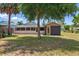 Exterior view of the home from the backyard, showing a storage shed and yard equipment at 1119 Pine Ave, Tavares, FL 32778