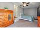 Cozy bedroom with carpet, ceiling fan, and a large wooden dresser on the left at 1119 Pine Ave, Tavares, FL 32778