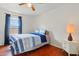 Comfortable bedroom with hardwood floors, natural light, and cozy blue bedding at 1119 Pine Ave, Tavares, FL 32778