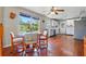 Cozy dining area with wood floors, a ceiling fan, and natural light from large windows at 1119 Pine Ave, Tavares, FL 32778