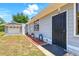 Inviting entrance of a home with secure black door and matching detached garage at 1119 Pine Ave, Tavares, FL 32778
