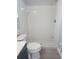 Well-lit bathroom offering a white tile shower with a modern shower head and white toilet at 112 Arlington Ct, Haines City, FL 33844