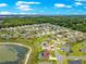 Elevated view of single-story home by a pond in a neighborhood with mature trees at 11215 Se 172Nd Place, Summerfield, FL 34491