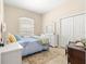 Cozy bedroom featuring a comfortable bed, dresser, and a window for natural light at 11215 Se 172Nd Place, Summerfield, FL 34491