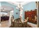 Cozy dining room with elegant chandelier, decorative tapestry, and views into the connected living spaces at 11215 Se 172Nd Place, Summerfield, FL 34491
