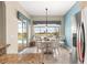 Bright and open breakfast nook with a view of the pool, white table and chairs plus stainless refrigerator at 11215 Se 172Nd Place, Summerfield, FL 34491