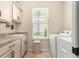 Charming laundry room featuring a sink, storage cabinets, a window with blinds and an included washer and dryer at 11215 Se 172Nd Place, Summerfield, FL 34491