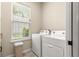 Bright laundry room with modern white appliances including a washer and dryer, with a window with natural light at 11215 Se 172Nd Place, Summerfield, FL 34491