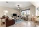 Open-concept living room with comfortable seating, TV, and seamless flow into the dining and kitchen areas at 11215 Se 172Nd Place, Summerfield, FL 34491