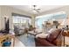 Inviting living room showcasing stylish furniture, large windows, and an open layout into the adjacent kitchen at 11215 Se 172Nd Place, Summerfield, FL 34491