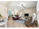 Spacious living room featuring comfortable seating, a ceiling fan, and seamless access to other areas at 11215 Se 172Nd Place, Summerfield, FL 34491