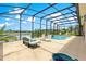 Relaxing screened-in pool area with comfortable seating and views of the serene lake at 11215 Se 172Nd Place, Summerfield, FL 34491